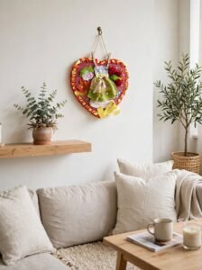 Handmade red heart wall decor with green dress, roses, yellow bow, embroidered Josephina's Dreams, upcycled fabric art hanging on white wall